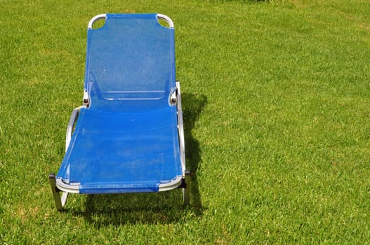 Lawn chair on green grass background. Garden furniture.