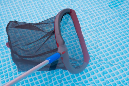 cleaning net in pool with plaid ground