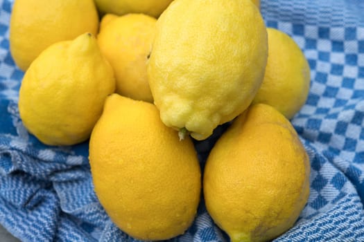 yellow lemons with blue towel on wooden ground