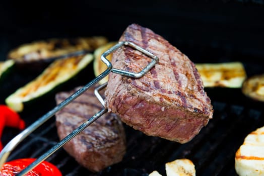 beef steak with different vegetables on barbecue
