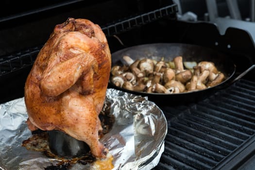 crunchy grilled completely chicken sitting on  barbecue