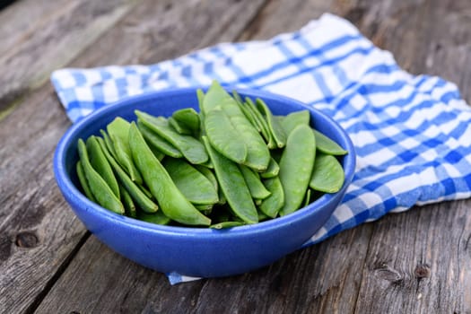 blue bowl with green peapods and towel