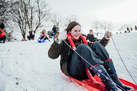 Close up shot of a little girl on a snow sled in a community race.