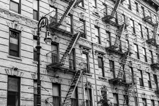 A fire escape of an apartment building in New York city. Graphical black and white image.