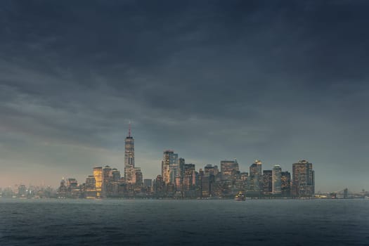 Dramatic panoramic view of storm over Lower Manhattan from Ellis Island at dusk, New York City.
