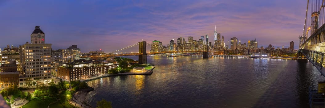 Brooklyn, Brooklyn park, Brooklyn Bridge, Janes Carousel and Lower Manhattan skyline at night seen from Manhattan bridge, New York city, USA. Wide angle panoramic image.