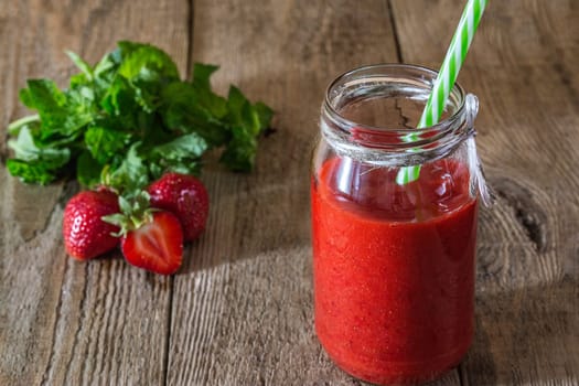Smoothies strawberry-mint in a jar on a wooden background