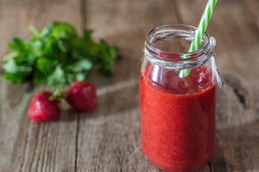 Smoothies strawberry-mint in a jar on a wooden background