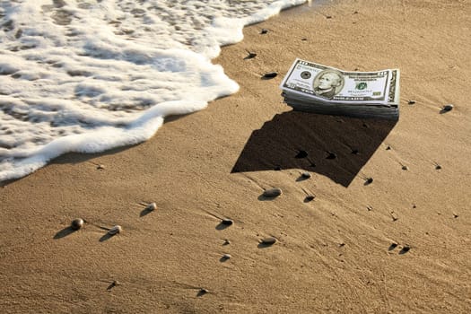 conceptual image of dollar pile on beach