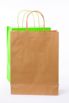 Variety of colored paper shopping bags on white background. Empty area.