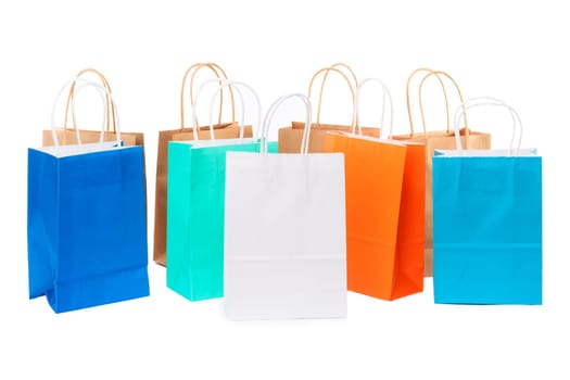 Variety of colored paper shopping bags on white background. Empty area.