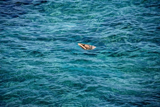 paper boat floating on clear sea