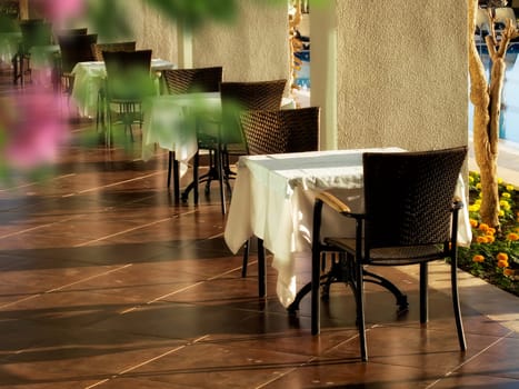 close up shot of outdoor empty restaurant table and chairs.