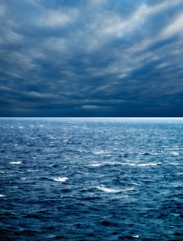 seascape image of windy weather and waves on sea over cloudy sky