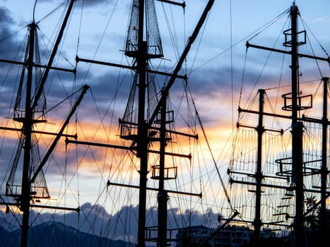 sailing boats silhouetted by sunset light in harbor of Antalya
