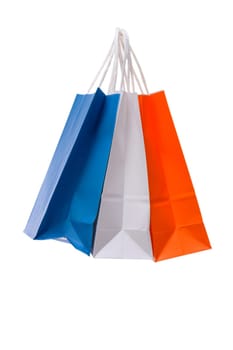 Variety of colored paper shopping bags on white background. Empty area.