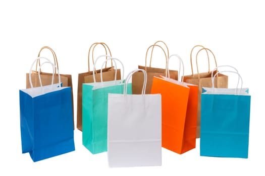 Variety of colored paper shopping bags on white background. Empty area.