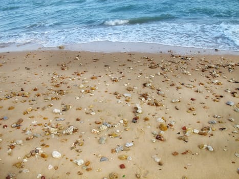 close up sand and pebbles on beach and waves