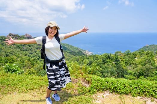 Women tourists extend the arms happily at high viewpoint to see the beautiful nature landscape of the sea and island on top of the Koh Tao island is a famous attractions in Surat Thani, Thailand