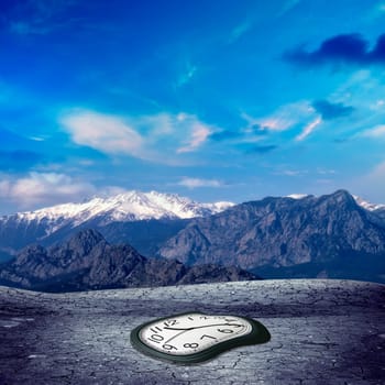 conceptual image of mountain and cracked soil with clock