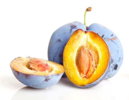 Untouched plum fruit with original color streight from tree, one plum divided in half