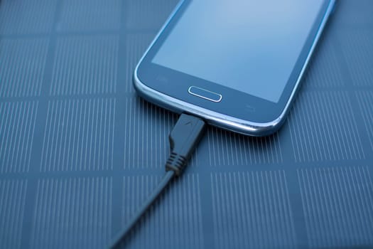 Use of renewable energy - Mobile Phone Chargers on grass in nature with Sun