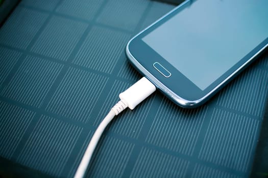 Use of green renewable energy - Mobile Phone Chargers on grass in nature with Sun