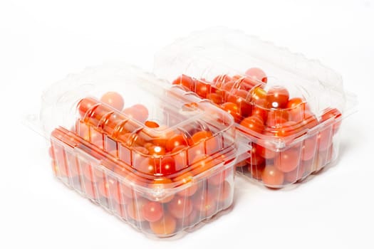 Cherry tomato in plastic cointainer packed and ready for market. Package of 500g, studio shoot on white