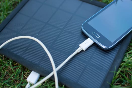 Use of renewable energy - Mobile Phone Chargers on grass in nature with Sun