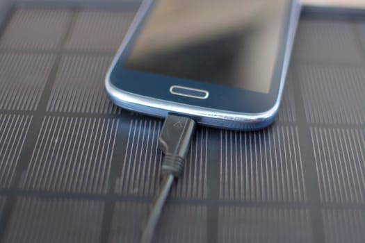 Use of renewable energy - Mobile Phone Chargers on grass in nature with Sun