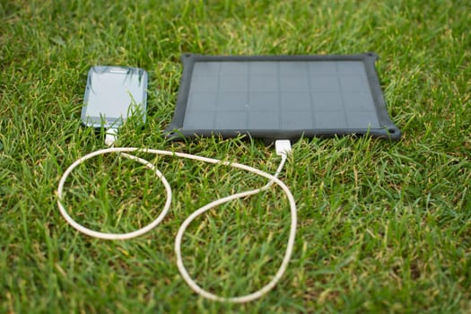 Use of renewable energy - Mobile Phone Chargers on grass in nature with Sun