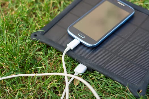 Use of renewable energy - Mobile Phone Chargers on grass in nature with Sun