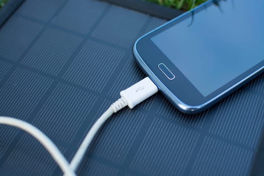 Use of renewable energy - Mobile Phone Chargers on grass in nature with Sun