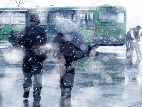 people walking on city street under snowing