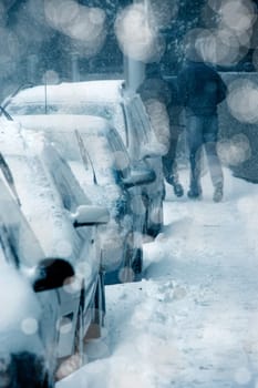 people walking on city street under snowing