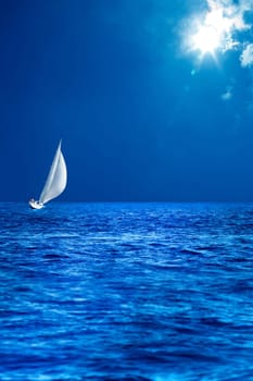 seascape image of sailing boat on sea over sunny sky.