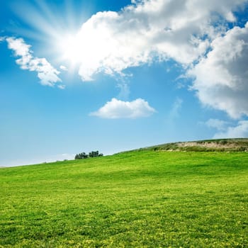 green landscape over sunny and cloudy sky