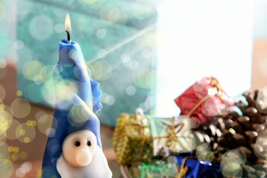 an image of Santa Clause candle and gift boxes in Christmas time