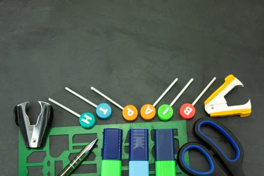 Closeup of colorful school supplies with copy space on blackboard background. Back to school.