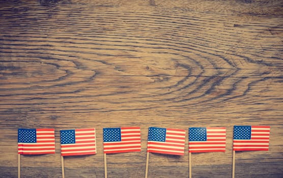 Small American flags on a rustic wooden background