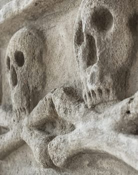 Skulls and crossbones carving on a cemetery wall