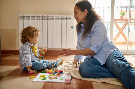 A loving mother shares an enriching moment with her young child while playing with educational toys, fostering development and bonding.