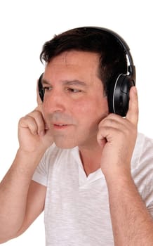 A good looking man sitting with his headphones on and.listening to music, isolated for white background.