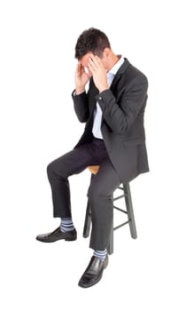 A tall man sitting in a dark suit with his hands on his face, is tired and.depressed, isolated for white background.