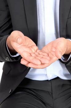 A close up image of the middle section of a business man holding his .hands open to receive something, isolated for white background.