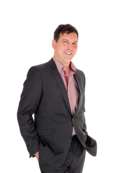 A happy businessman standing in a dark suit and checkered shirt with. his hands in in pocket, smiling, isolated for white background.