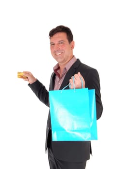 A smiling very happy man in a suit going shopping with his credit card.and shopping bag, isolated for white background.