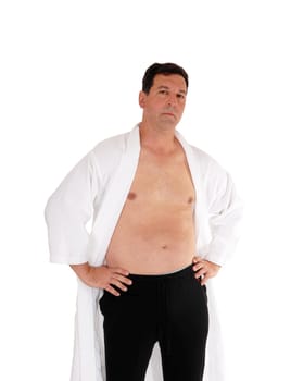 A handsome man standing in a white bathrobe and without shirt with.his hand on his hips, isolated for white background.