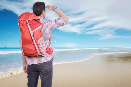 Rear view of asian traveler man looking at view on the beach