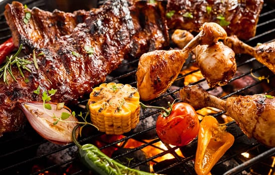 Portions of spicy spare ribs and chicken legs grilling over a hot fire on a BBQ with assorted fresh summer vegetables